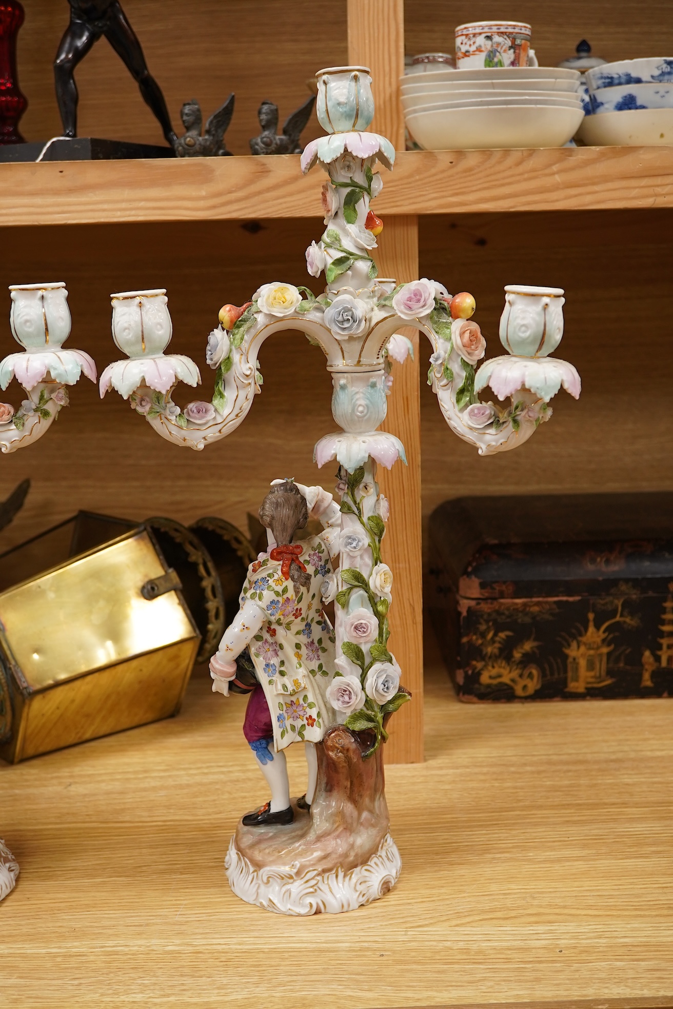 A pair of Volkstedt porcelain figural three branch candelabra with floral encrusted decoration, 51cm high